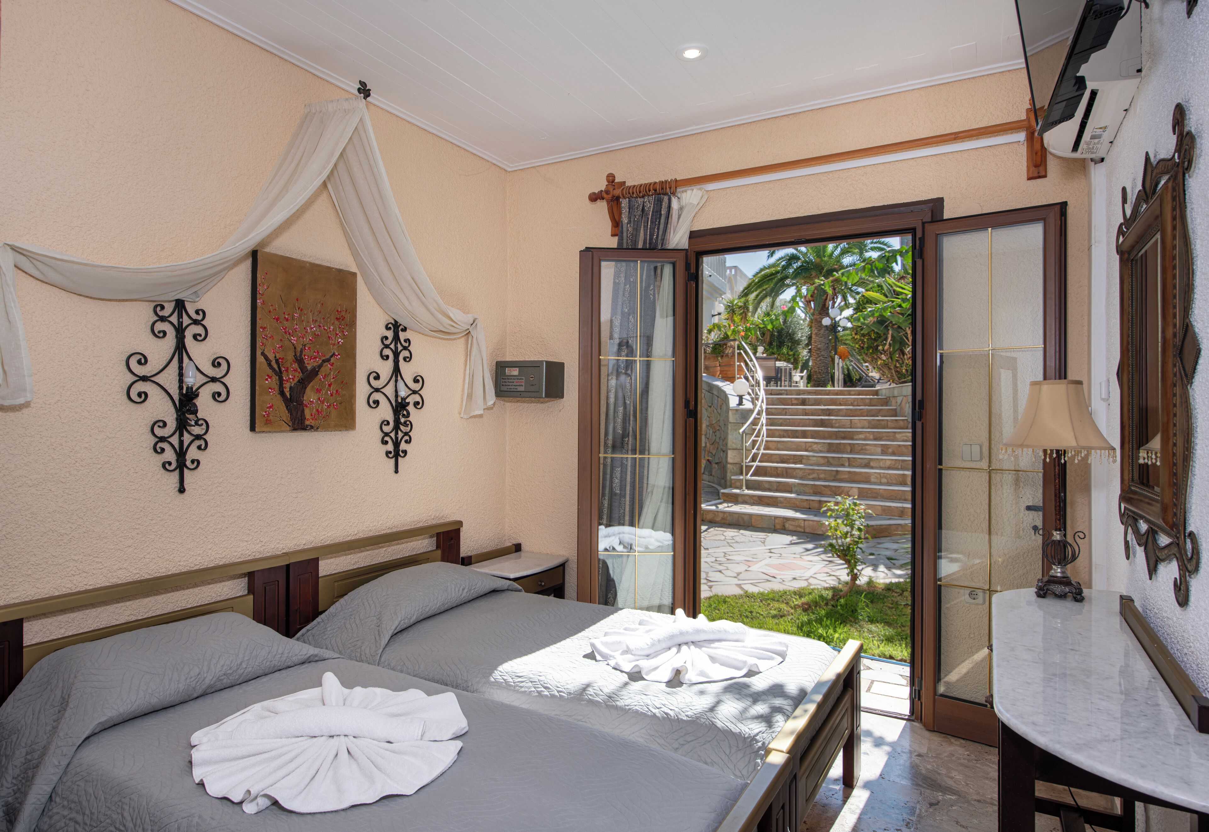 A hotel room with a bed, a bathroom, and a view of a staircase leading to a balcony.