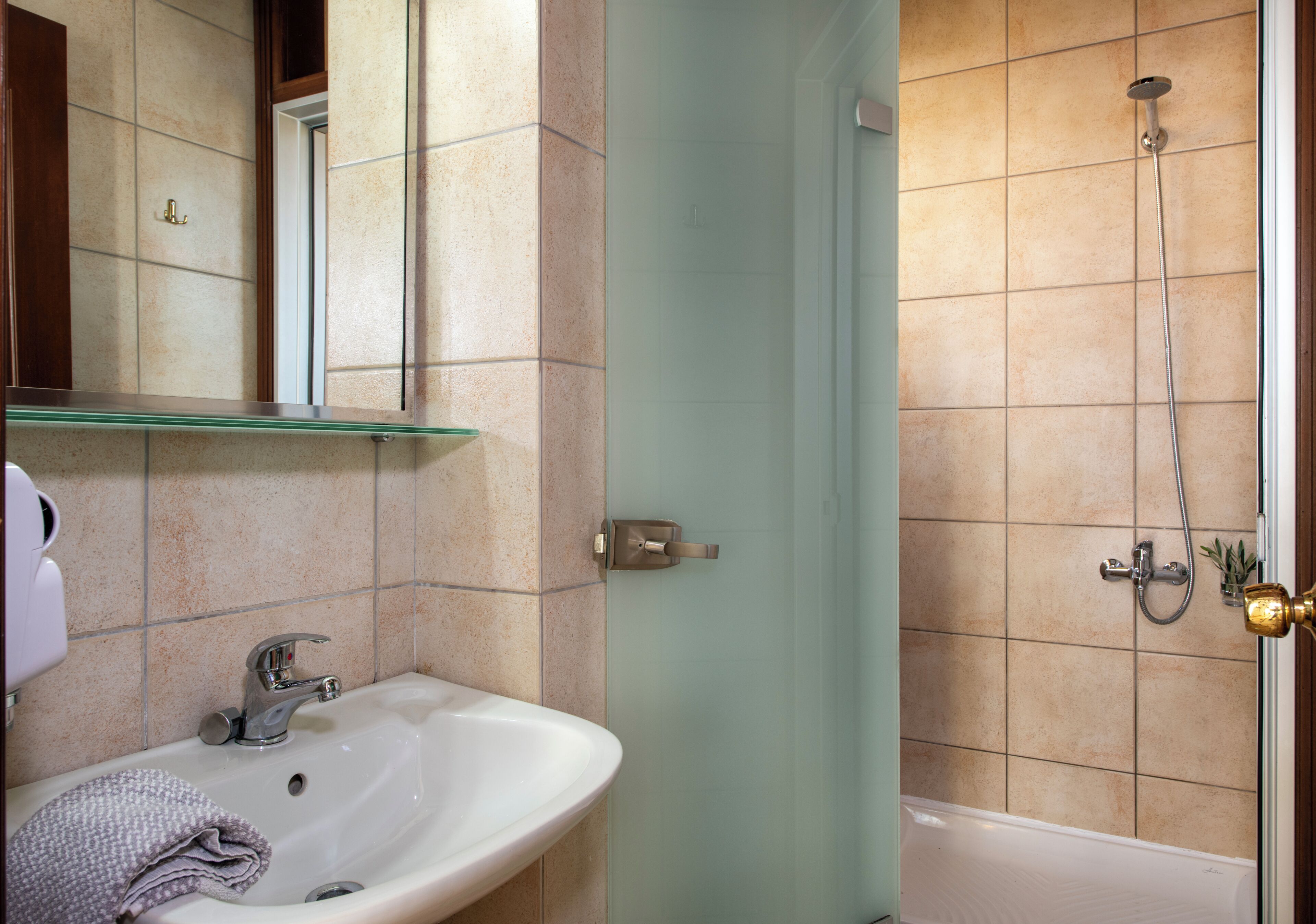 Une salle de bain avec un lavabo, un miroir et une douche.