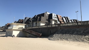 A modern building with a unique architectural design, featuring multiple levels and a prominent staircase. - NEW !! Full sea view. Charming apartment 3 bedrooms private parking  (Cabourg)
