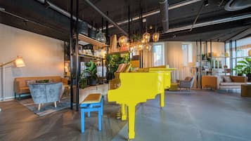 Ett modernt vardagsrum med ett knallgult piano, en blå bänk och en soffa.