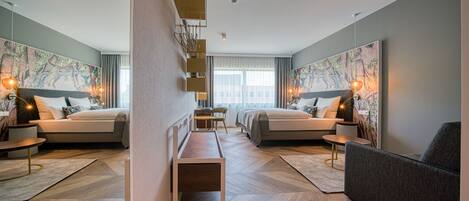 Una habitación de hotel moderna con dos camas, un sofá, un escritorio y obras de arte en las paredes.