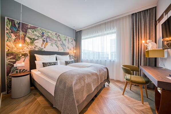 Habitación de hotel moderna con una cama grande, un escritorio y una silla. Hay un cuadro en la pared y una ventana con cortinas.