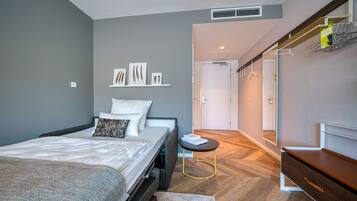 Un dormitorio moderno con cama, mesita de noche y armario.