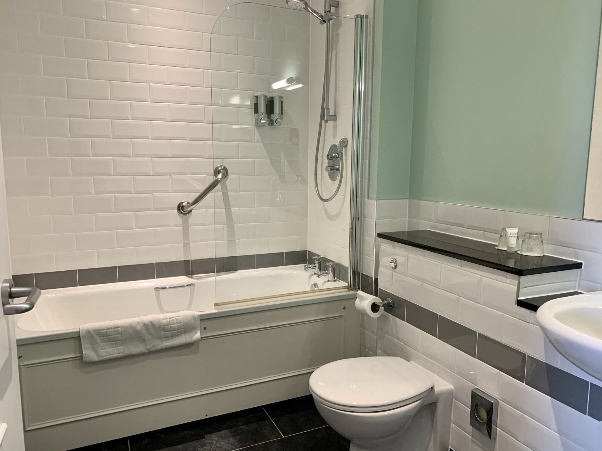 Un baño moderno con ducha envuelta en vidrio, una bañera, un inodoro y un lavamanos.