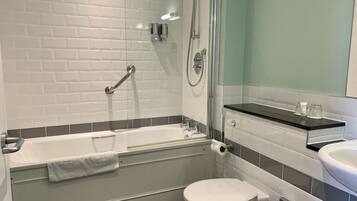 Un baño moderno con ducha envuelta en vidrio, una bañera, un inodoro y un lavamanos.