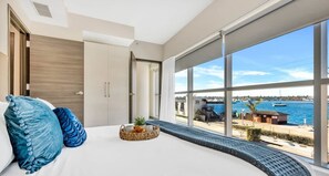 A modern bedroom with a large bed, a view of the sea, and a balcony with outdoor furniture. - Costa Hollywood (Hollywood)