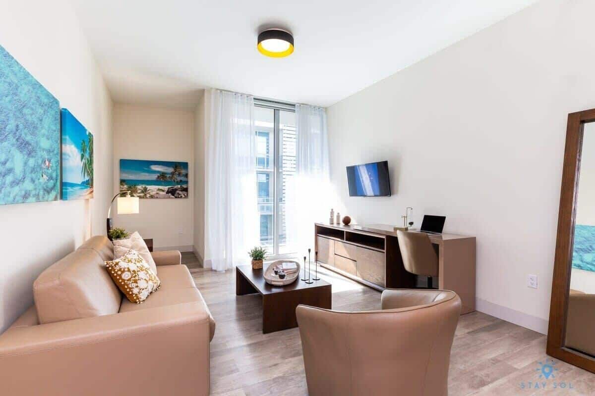 A modern living room with a sofa, coffee table, and a TV.