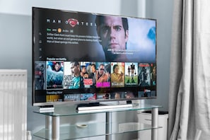 A television displaying a movie titled 'Man of Steel' with a subtitle about Drifter Clark Kent. - Luxury City Centre Apartment - Close to Chinatown - Secure Parking (West Midlands)