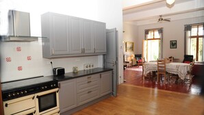 A kitchen with a stove, oven, and cabinets, and a dining area with a table and chairs. - Classic France Double:AC, BBQ, fresh&clean, garden (Limoux)