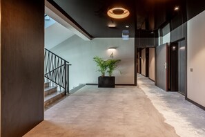 A modern hallway with a staircase, a potted plant, and a sign indicating room number 4. - Ferienwohnung am Meer, Urlaub auf der Insel Usedom, Appartement Albus 419 (Swinoujscie)