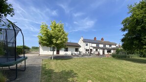 A residential property with a grassy yard, a trampoline, and a tree. - Converted Stables - Pet Friendly - Enclosed Garden (Pontefract)