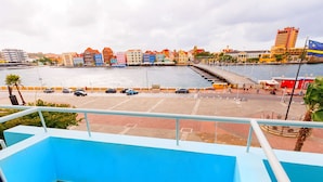 Une vue sur le front de mer, avec des bâtiments aux couleurs vives, une jetée et un drapeau.