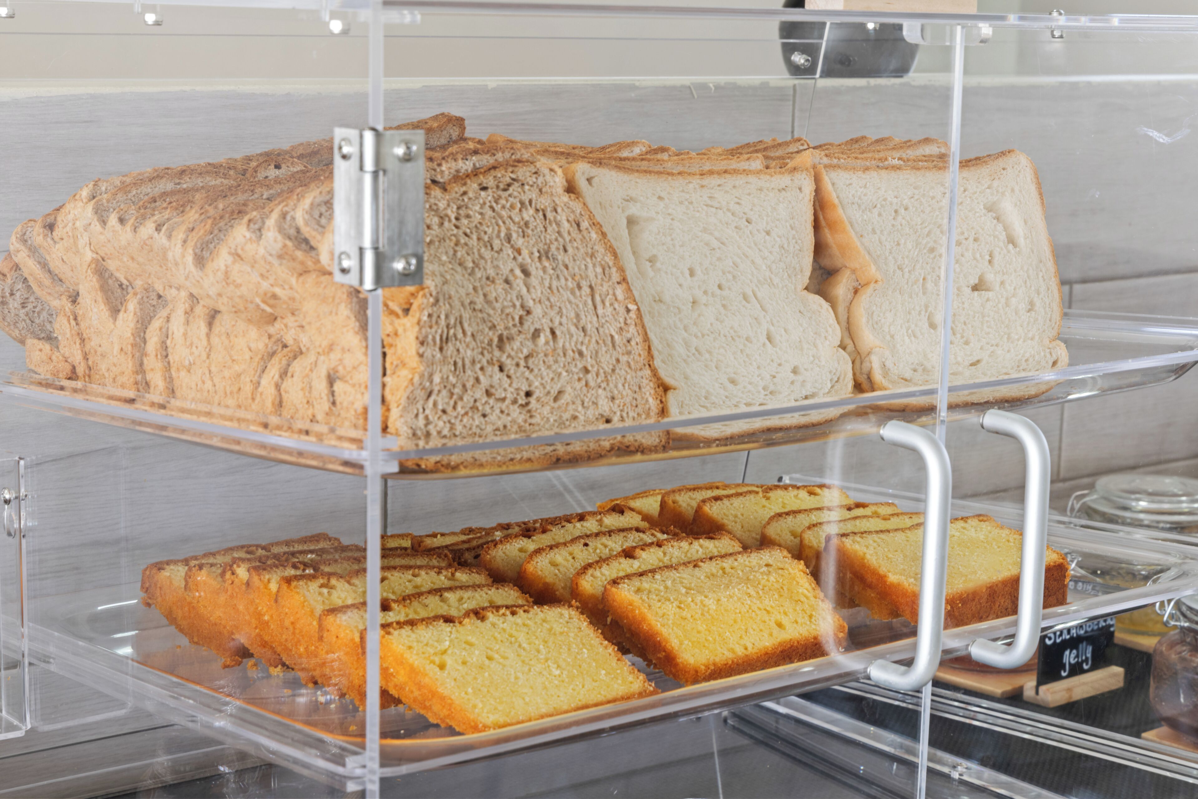 Una vitrina de panadería con distintos tipos de pan y pasteles.