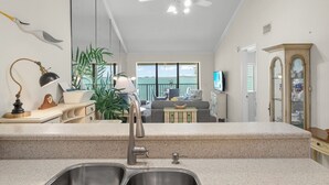 Una cocina con vista al mar, un ventilador de techo y un comedor también con vistas.