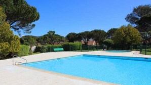 A rectangular swimming pool with a tiled deck, surrounded by a green fence and trees. - Mazet between Gassin and Cogolin, 5 km from Saint Tropez (Gassin)