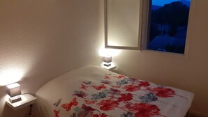 A bedroom with a bed, two bedside lamps, a window with a view of a mountain, and a night sky. - Mazet between Gassin and Cogolin, 5 km from Saint Tropez (Gassin)