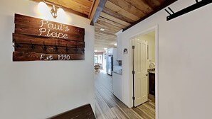 A hallway with a wooden sign reading "Paul's Place" and "Est. 1990". - Spacious 2 Bedroom Condo Great For Friends and Families! Hiking, Swimming, Stargazing! by RedAwning (Mammoth Lakes)