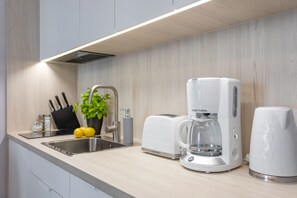 ثلاجة، موقد طهي مسطح، غسالة أطباق، ماكينة لصنع القهوة/الشاي