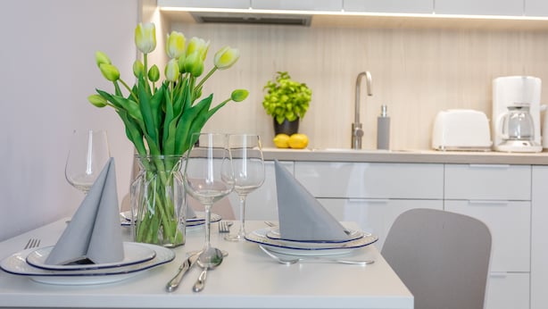 A modern kitchen with white cabinets, a coffee maker, and a vase with green leaves. - Ferienwohnung am Meer, Urlaub auf der Insel Usedom, Appartement Pegaz 10 (Swinoujscie)
