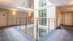 A multi-level interior with glass railings, a fire extinguisher, and a fire alarm on the wall. - Ferienwohnung am Meer, Urlaub auf der Insel Usedom, Appartement Pegaz 10 (Swinoujscie)