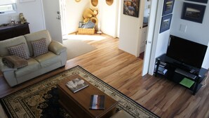 Un salon avec un canapé, une table basse et un téléviseur.