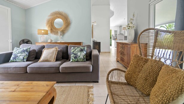 A modern living room with a grey sofa, wicker chairs, and a wooden coffee table. - Nature Paradise - Four Bedroom Villa, Sleeps 8 (Rivière-Pilote)