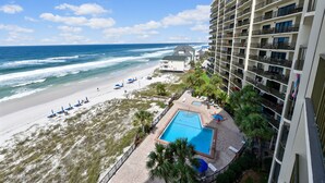 A high-rise hotel with a pool and beach access.