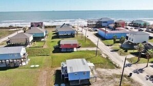 Zona residencial costeira com casas, uma praia e vista clara do oceano.