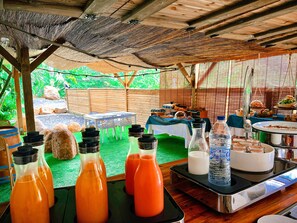 A dining area with tables, chairs, and a buffet setup. - Kawan Bay Suites (Deshaies)