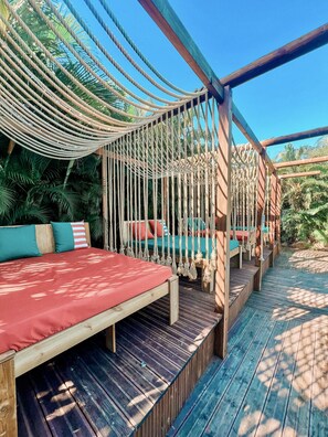 Una piscina al aire libre, sombrillas, sillones reclinables de piscina