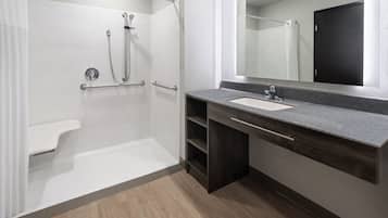 Ein modernes Badezimmer mit Dusche, Waschbecken und Spiegel.