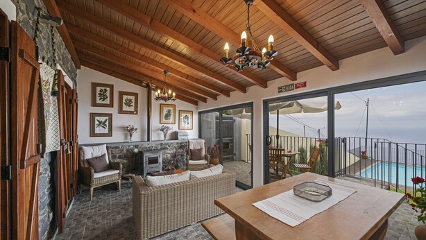 A cozy interior with a stone fireplace, wicker furniture, and a wooden table.