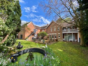 A residential property with a garden, outdoor seating, and a pond. - Pickwicks Guest House (Oxford)
