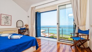A bedroom with a bed, a chair, a desk, and a view of the sea. - Beachfront twin villa, private heated pools and amazing sea views - Villa Violet (Supetar)