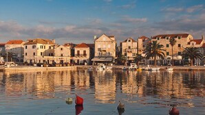 A waterfront view with traditional stone buildings, calm water, and boats. - Beachfront twin villa, private heated pools and amazing sea views - Villa Violet (Supetar)