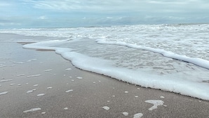 A beach with waves gently lapping onto the shore.