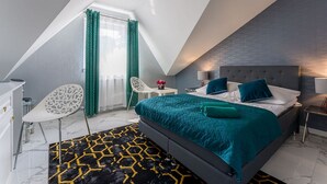 A modern bedroom with a large bed, a desk, and a chair.