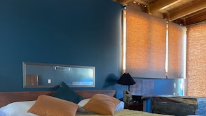 Habitación de hotel con una cama grande, techo de madera y vistas al exterior.