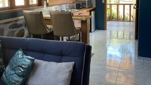 Una cocina moderna con comedor, un sofá con cojines y vistas al exterior.