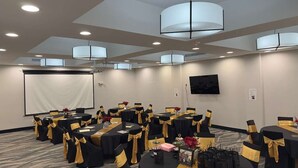 A conference room with round tables, black and gold tablecloths, and chairs. - Merica Inn & Suites (Wills Point)