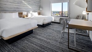 A hotel room with two beds, a desk, a chair, and a large window offering a city view. - TownePlace Suites by Marriott Wrentham Plainville (Plainville)