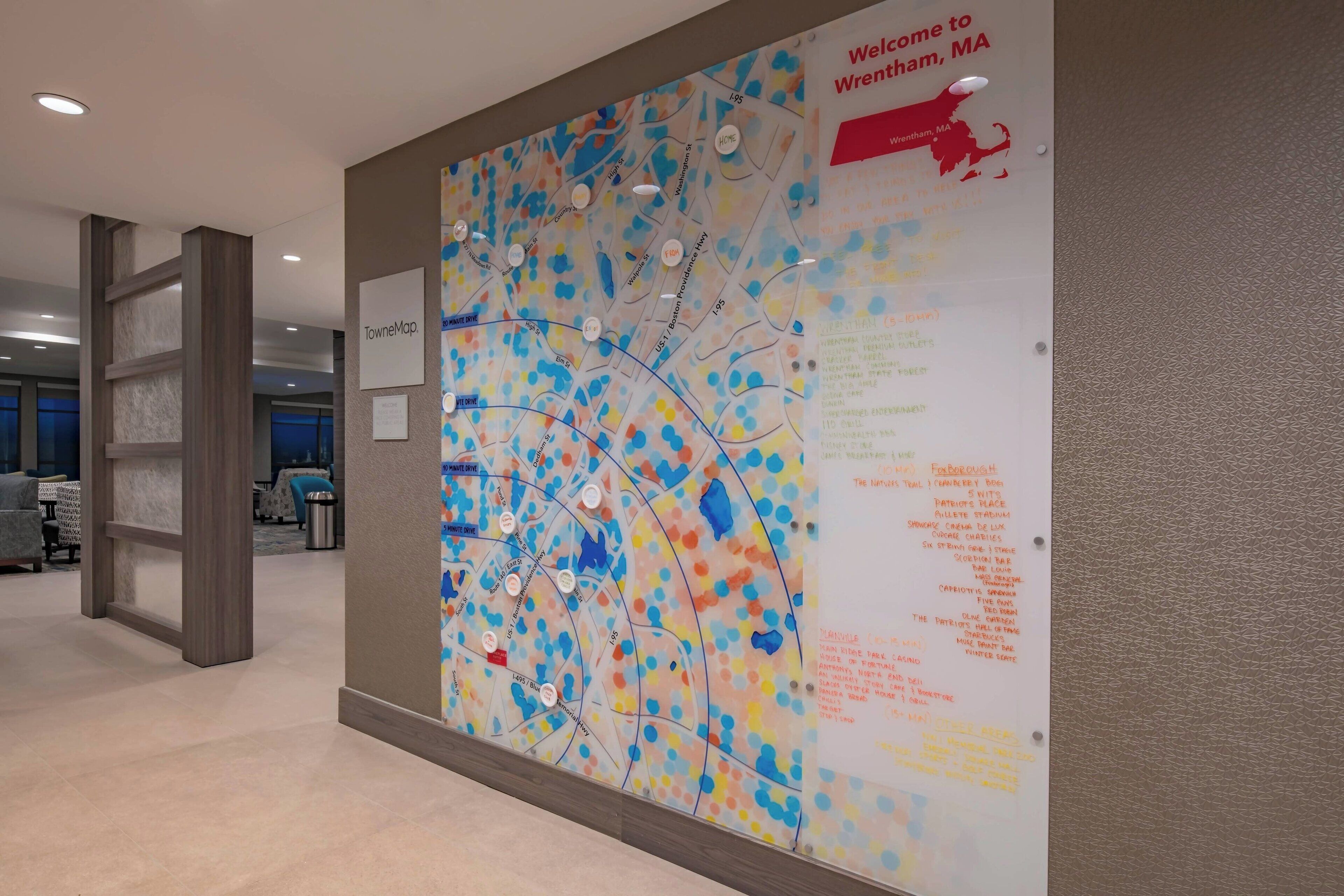 A wall with a colorful map and a welcome sign for Wrentham, MA.