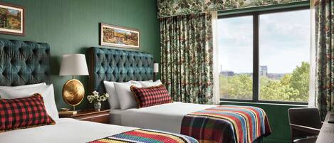 A hotel room with two beds, green walls, floral curtains, a large window with a city view, and a classic chandelier.