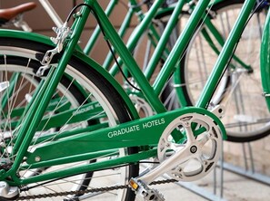 A green bicycle with a chain and gear mechanism.