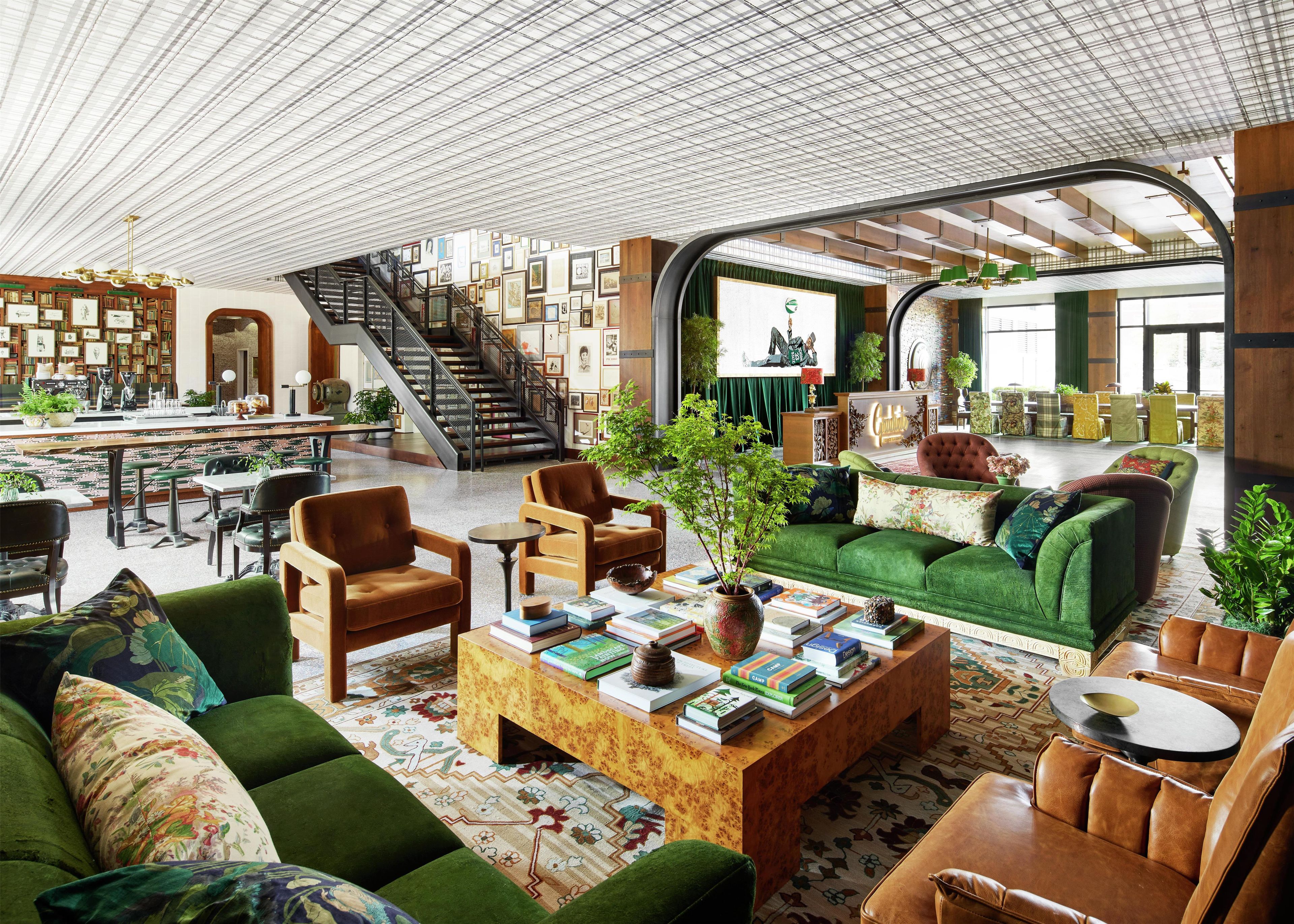 A spacious library with bookshelves, a staircase, and comfortable seating areas.