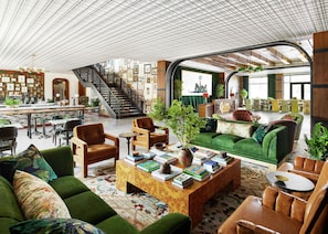A spacious library with bookshelves, a staircase, and comfortable seating areas.