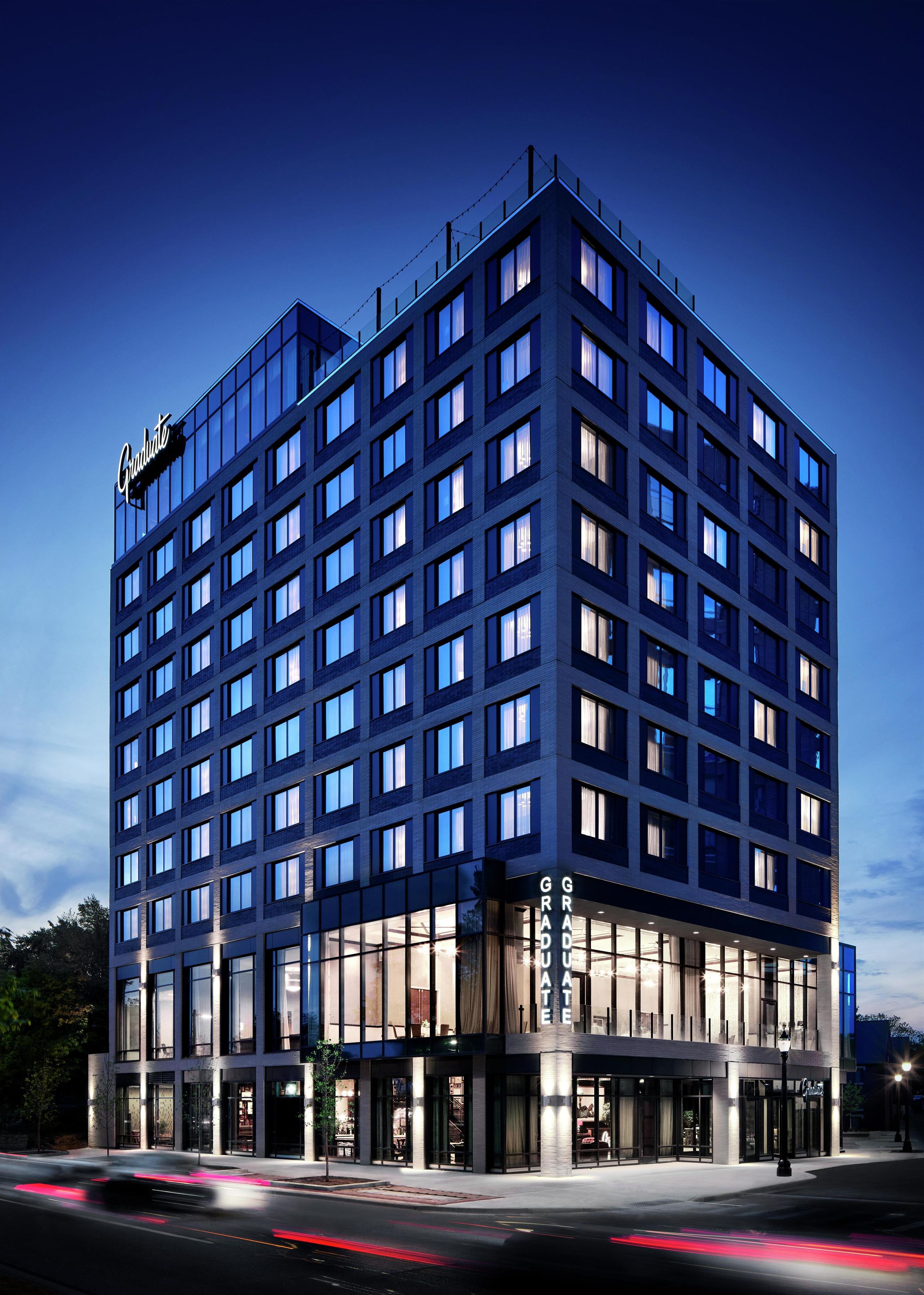 A multi-story hotel with a modern glass facade, multiple balconies, and a prominent 'Graduate' sign.