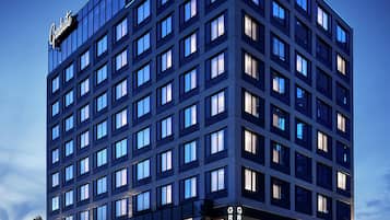 A multi-story hotel with a modern glass facade, multiple balconies, and a prominent 'Graduate' sign.