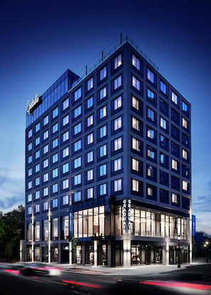 A multi-story hotel with a modern glass facade, multiple balconies, and a prominent 'Graduate' sign. - Graduate by Hilton East Lansing (East Lansing)