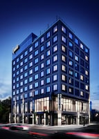 A multi-story hotel with a modern glass facade, multiple balconies, and a prominent 'Graduate' sign.